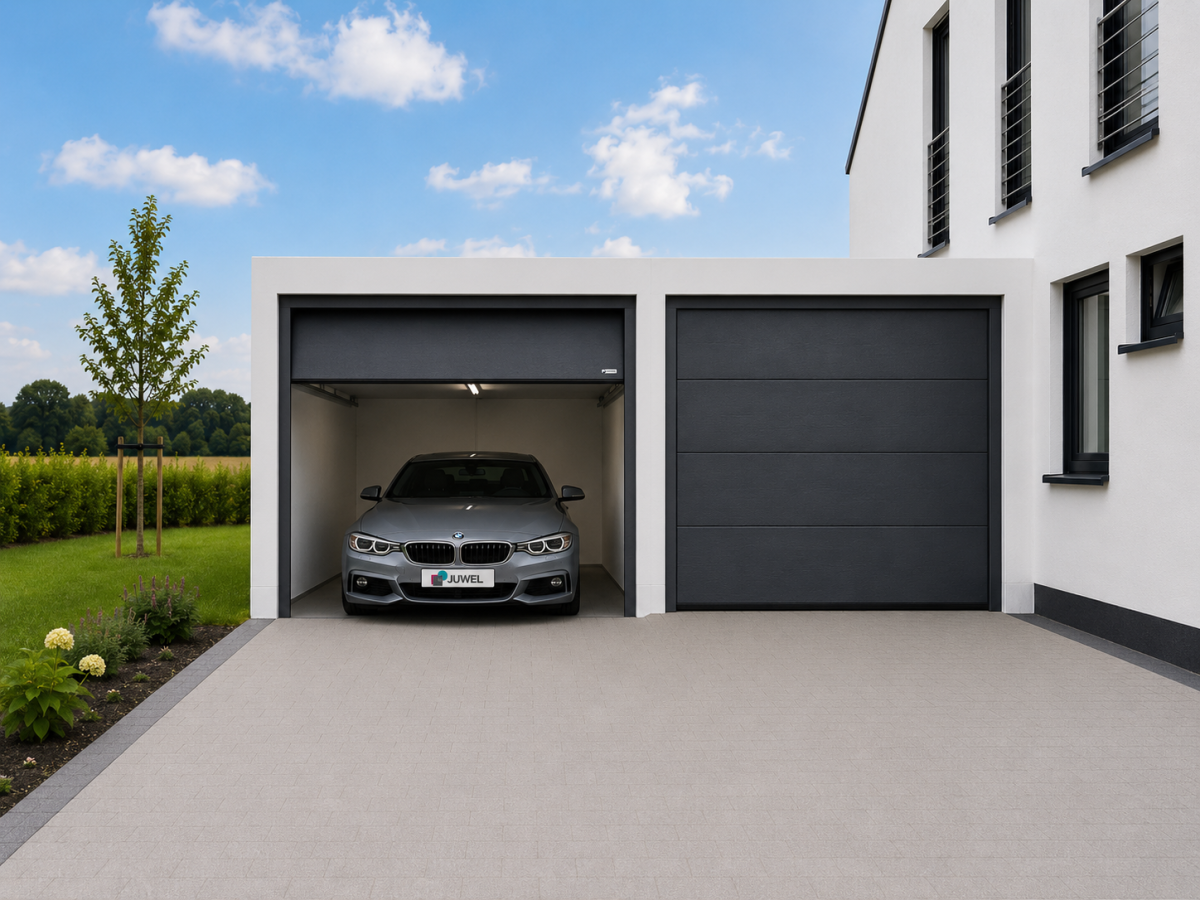 Modernes Haus mit Doppelgarage. Dunkelgraues Auto steht in geöffneter Garage, daneben geschlossene Garagentür. Rasen und Hecke im Hintergrund.