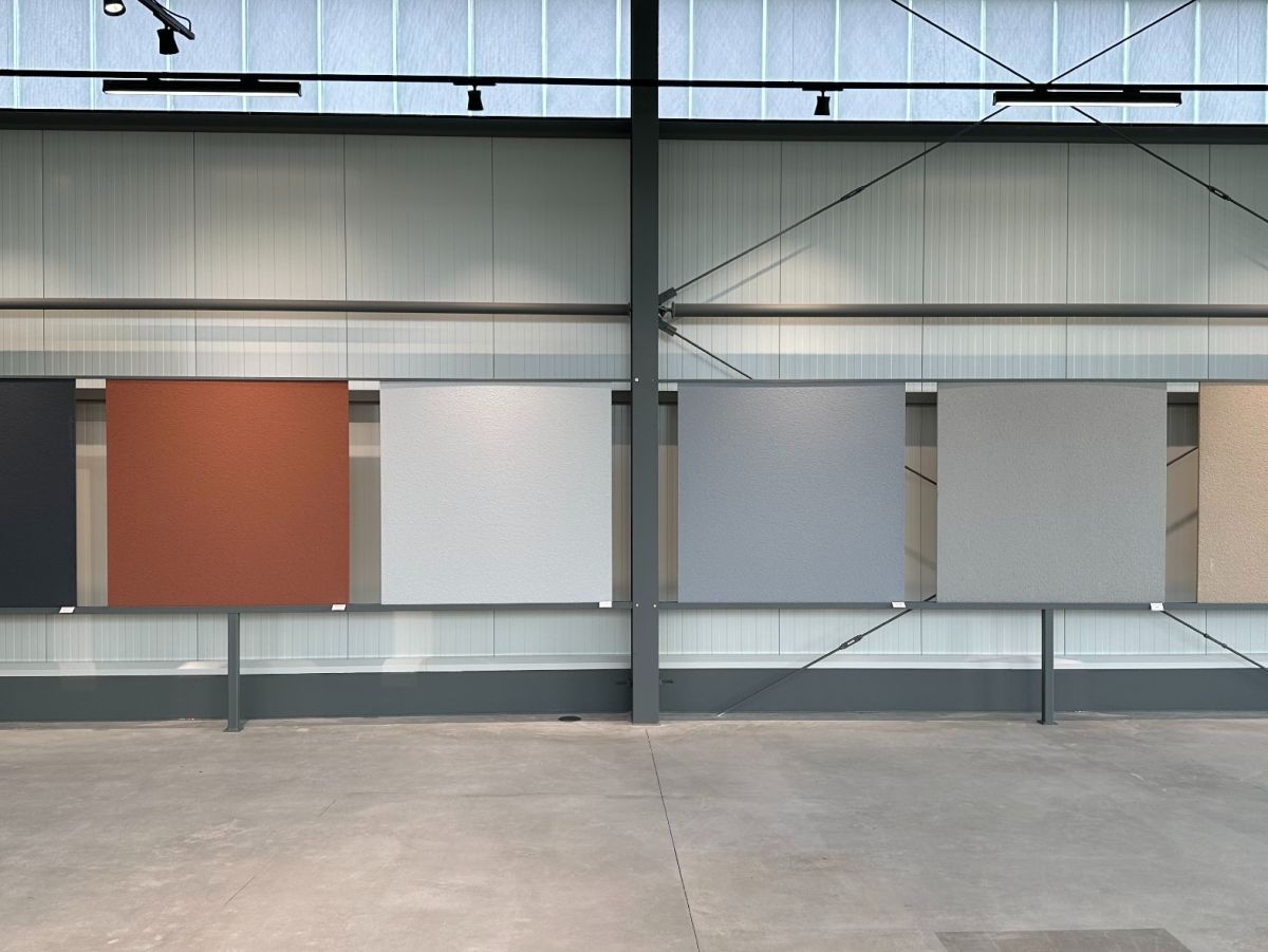 Großer Raum mit Metallstruktur und sieben Farbtafeln an der Wand.