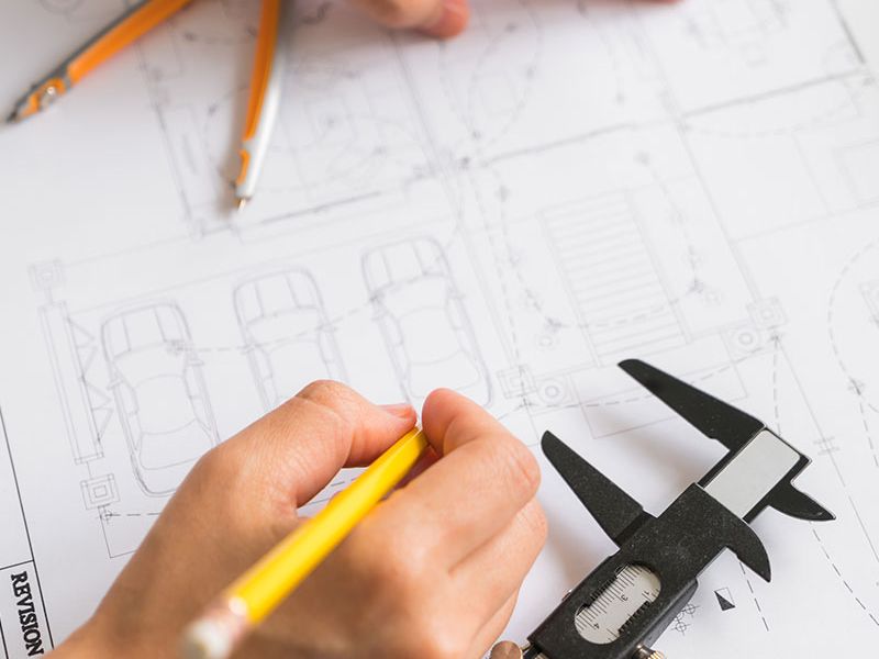 Architekt plant über technischen Zeichnung mit Bleistift, Zirkel und Messschieber.